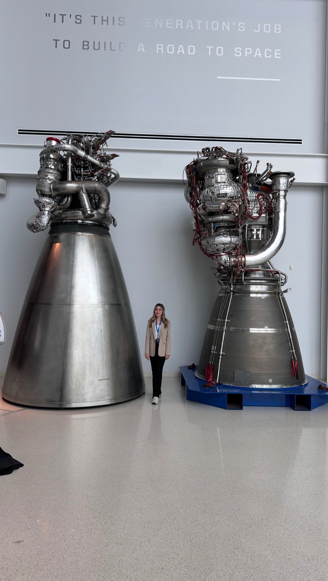 Iris Robles standing between two full-scale rocket engines